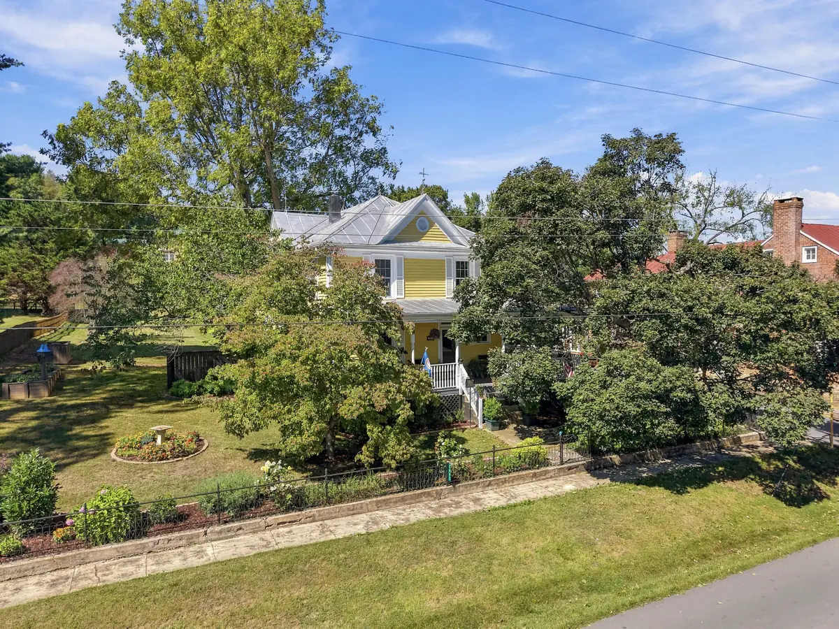 Drone photo of a yellow Victorian home on a tree-lined lot in Brownsburg, VA