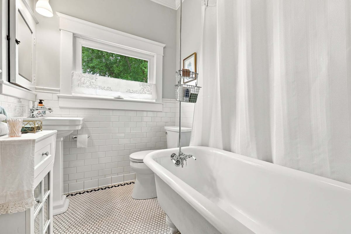 Period bathroom with subway tile, hex floor tile and a clawfoot tub