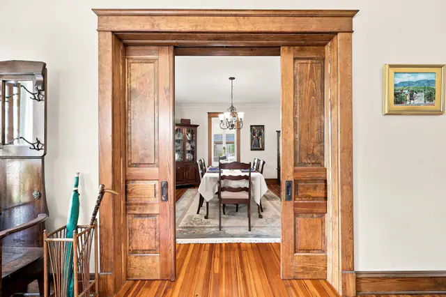 Antique pocket doors opening into a dining room, the kind of flow a 3D tour lets buyers walk