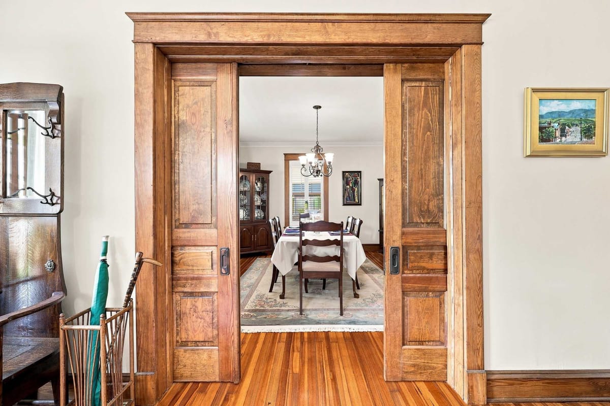 Original pocket doors and millwork framing a dining room beyond
