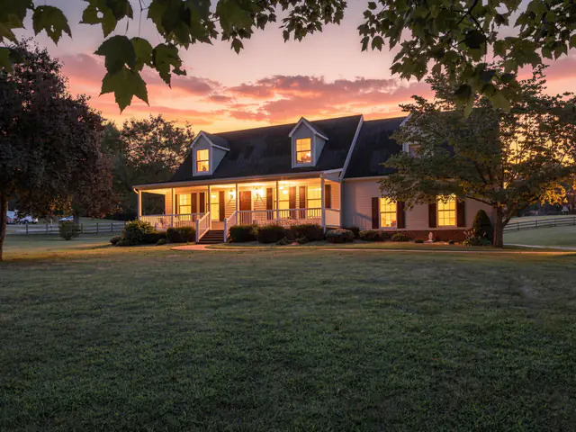 Twilight exterior photography: Cape Cod with a lit front porch at sunset